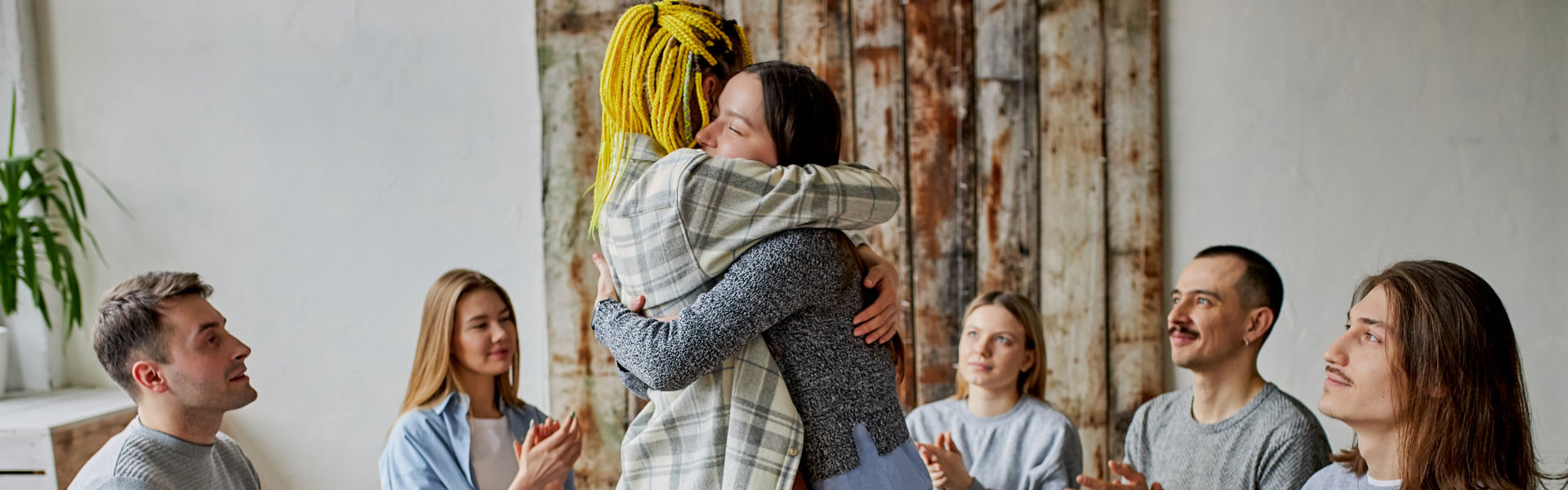 group of people clapping for the two women hugging